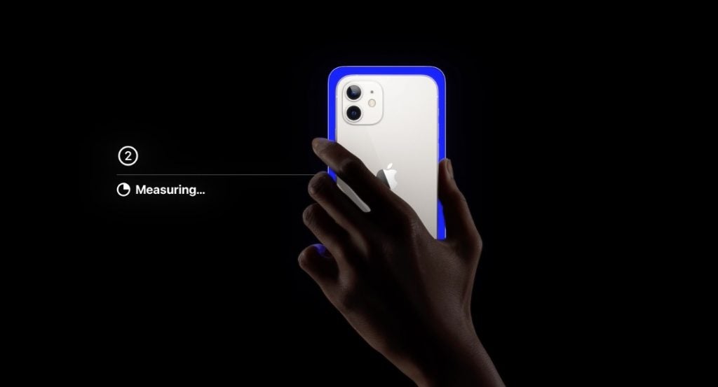 Ein blau-weißes iPhone in der Hand auf schwarzem Hintergrund, das die Farbbalance von Apple TV zeigt