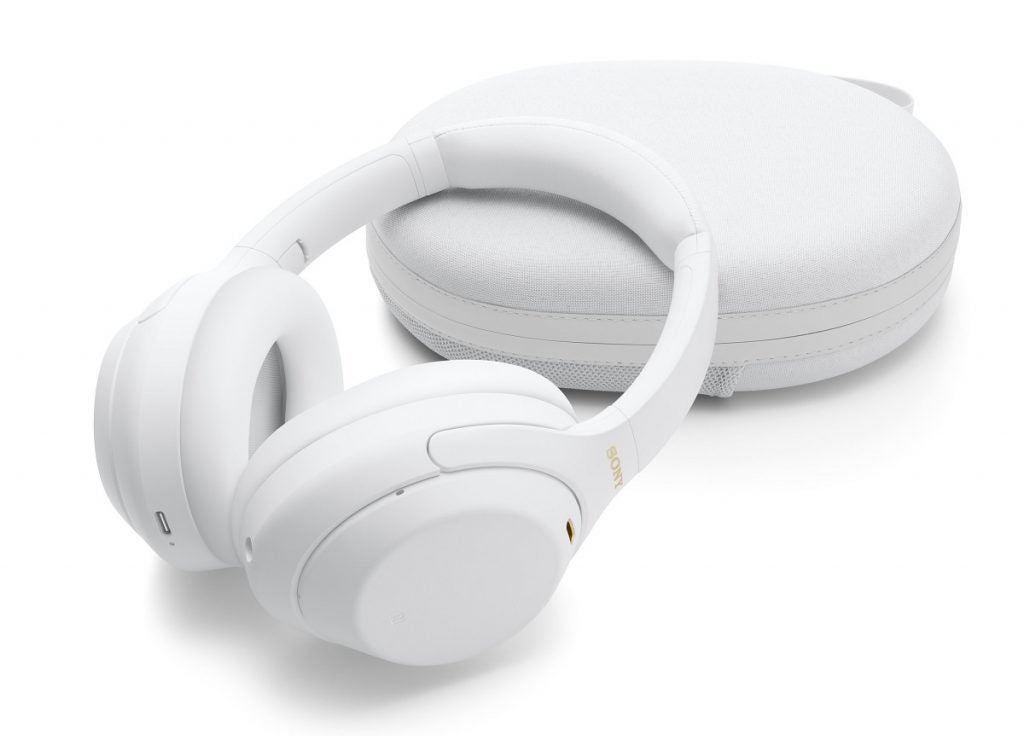Weißer Sony WH1000 XM4 stützt sich auf sein weißes Gehäuse auf weißem Hintergrund