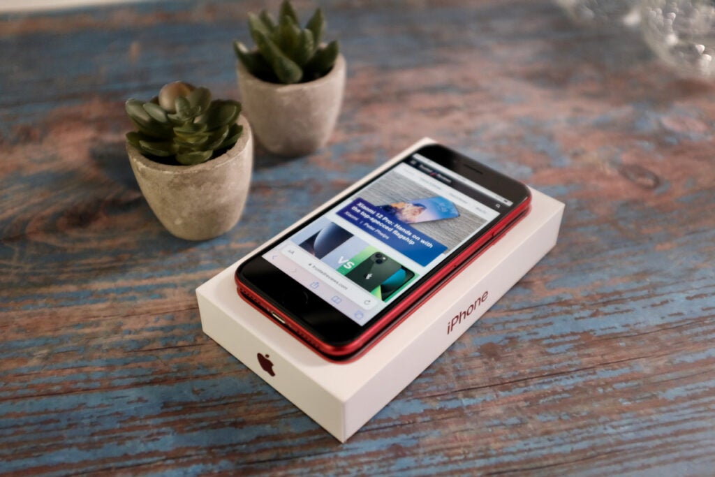 Das iPhone SE 2022 in Rot, zusammen mit der Verpackung