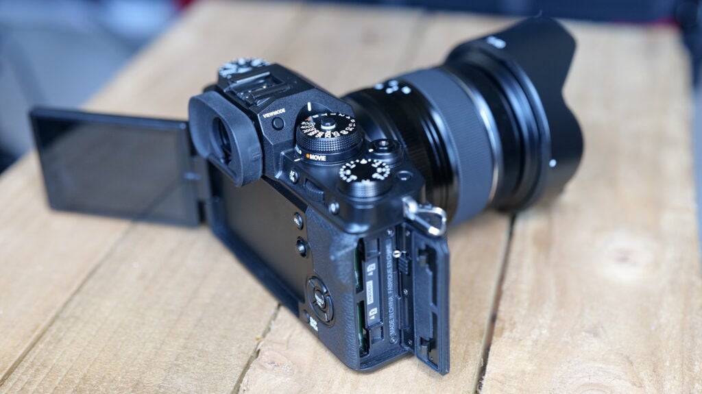 Rechtwinklige Ansicht einer schwarzen Fujifilm XT4-Kamera, die auf einem Holztisch steht, Rückansicht