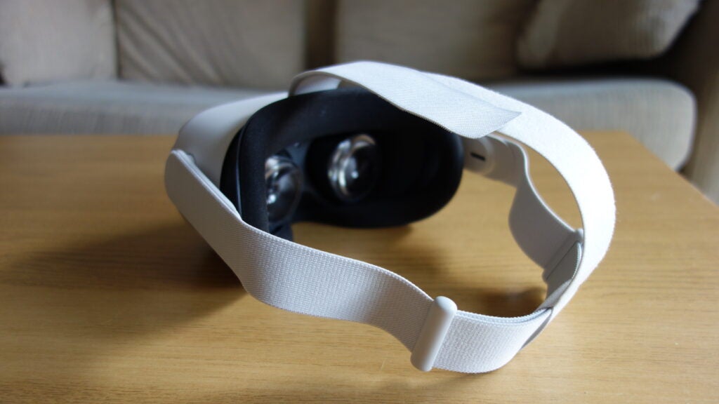 Eine weiße Oculus Quest 2 auf einem Holztisch, Ansicht von vorne links