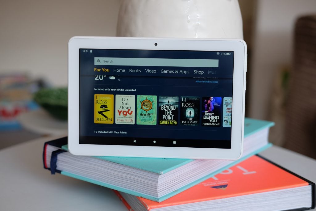 Ein weißer Amazon Kindle, der auf Büchern steht und den Homescreen des Geschäfts anzeigt