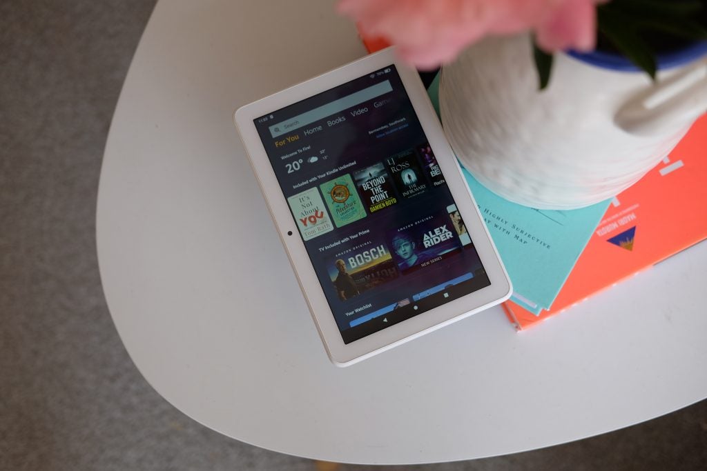 Blick von oben auf einen weißen Amazon Kindle, der auf Büchern liegt, auf denen der Homescreen eines Geschäfts angezeigt wird