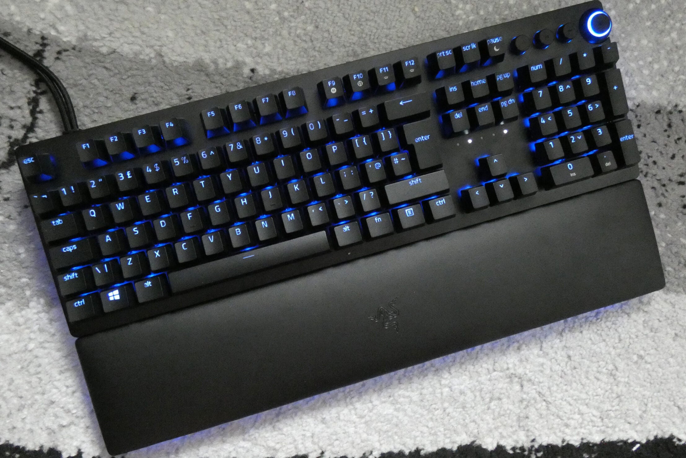 Ansicht von oben auf eine schwarze Huntsman V2-Analogtastatur mit blauen Lichtern unter den Tasten