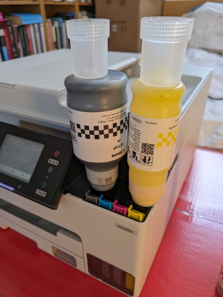 Schwarze und gelbe Tintenflaschen füllen den Drucker