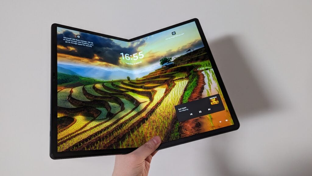Hand hält Lenovo ThinkPad X1 Fold mit Hintergrundbild im Querformat.