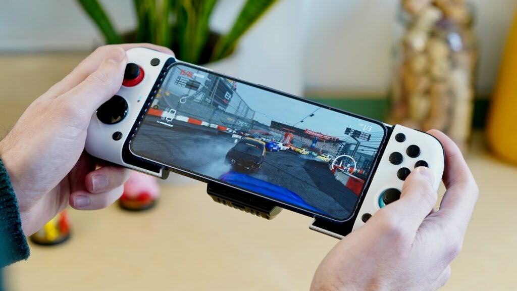 Hände halten den GameSir X3-Controller am Smartphone mit Rennspiel.