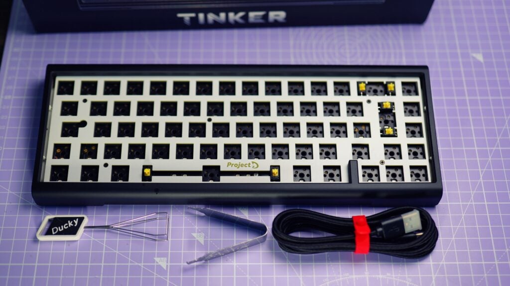 Ducky ProjectD Tinker 65 Barebone-Tastatur auf dem Schreibtisch mit Zubehör.