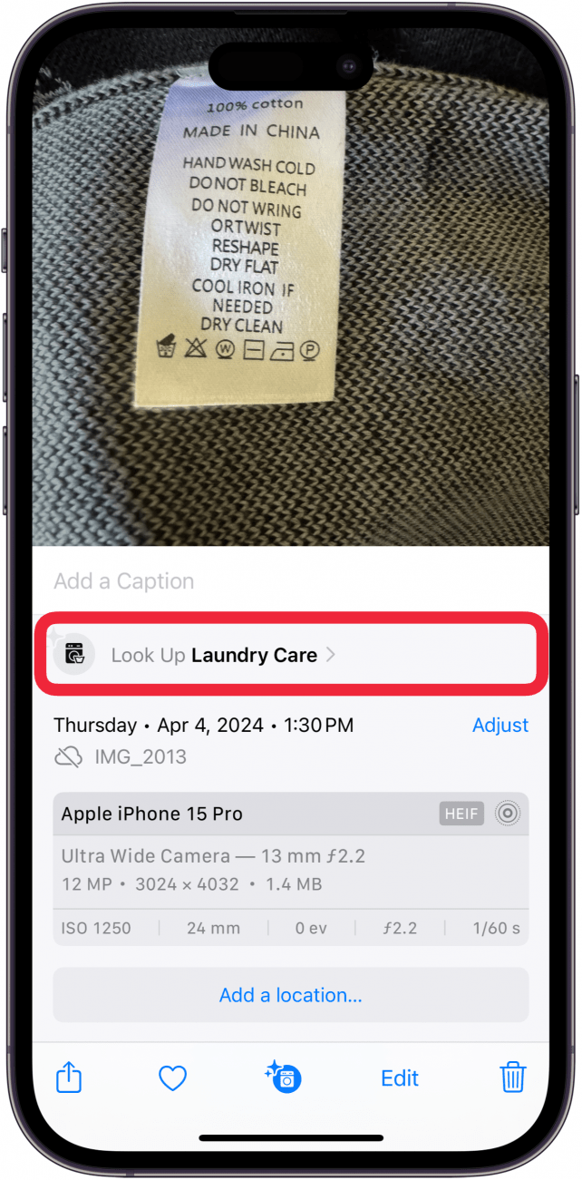 iPhone-Fotos-App mit einem Foto, einem Wäscheetikett auf einem Pullover, geöffnetem Infomenü und einem roten Kästchen darum herum 