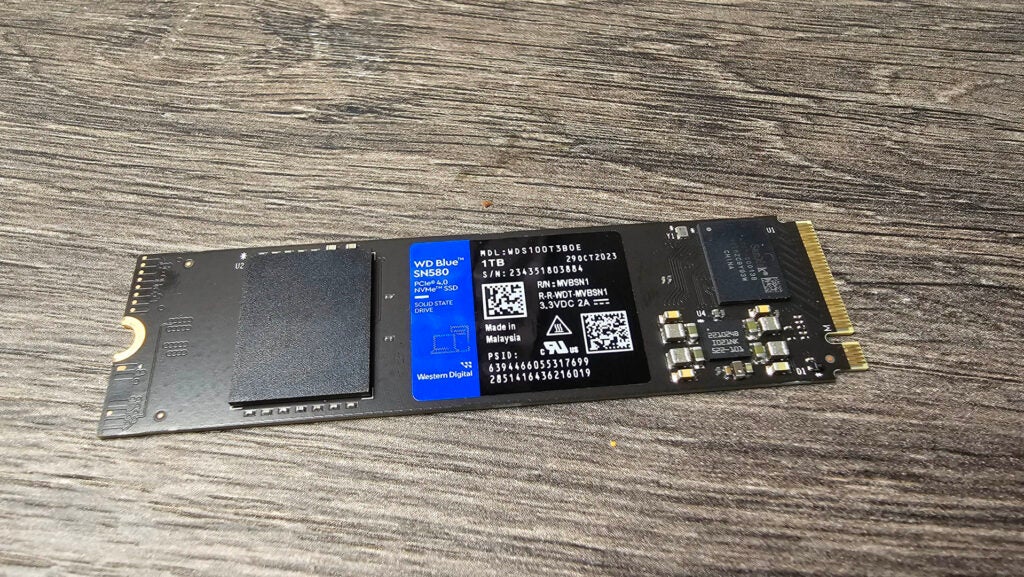 WD Blue SN580 PCIe 4.0 M.2 SSD 1 TBWD Blue SN580 1 TB NVMe SSD auf Holzoberfläche.